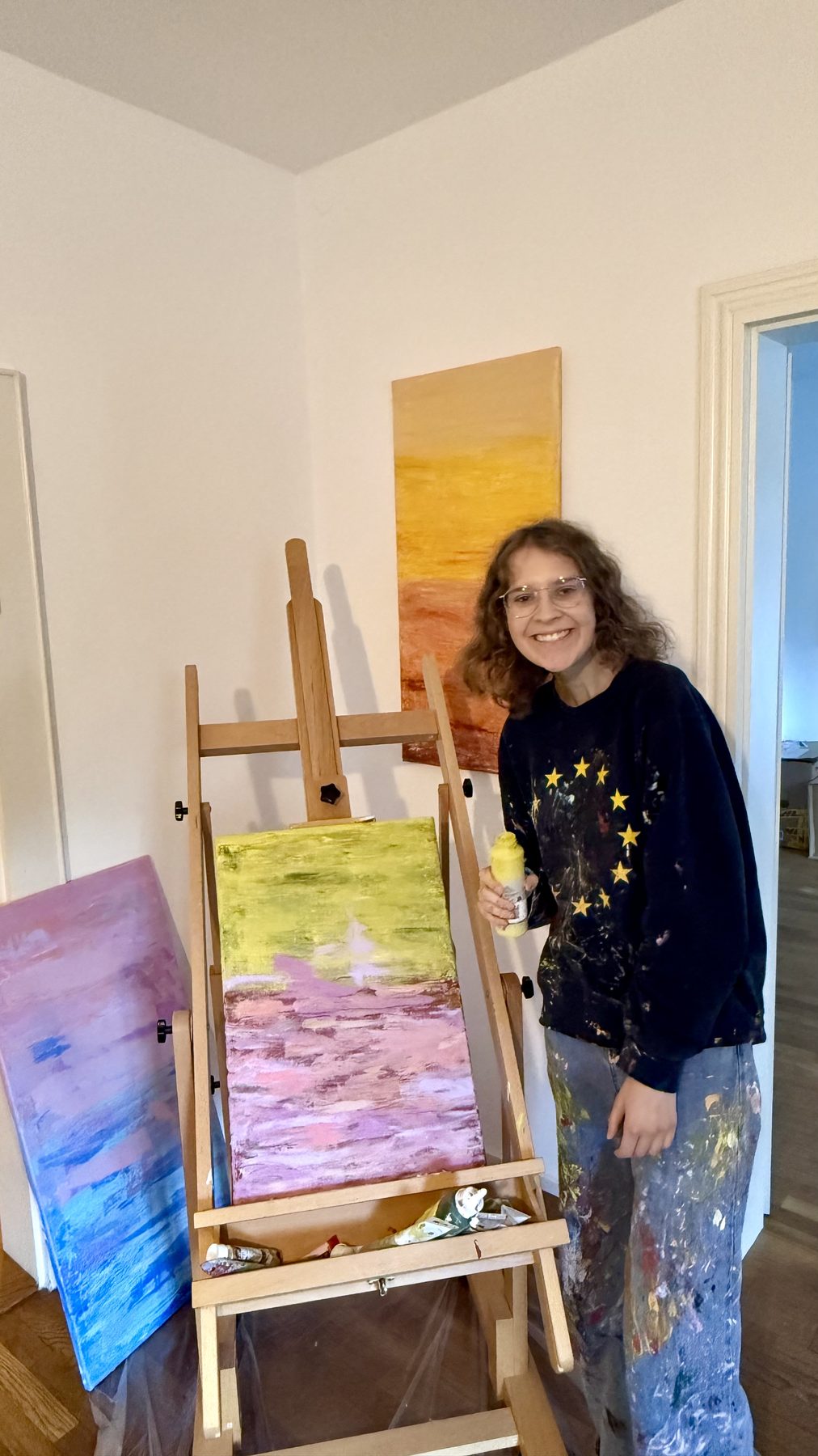 Lina an der Staffelei mit Werk in Maigrün und Rosa