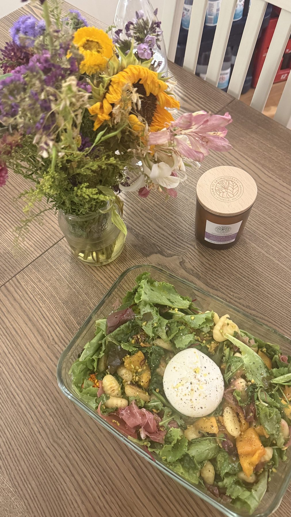 Frisch gekochter Salat mit Blumenstrauß auf dem Tisch