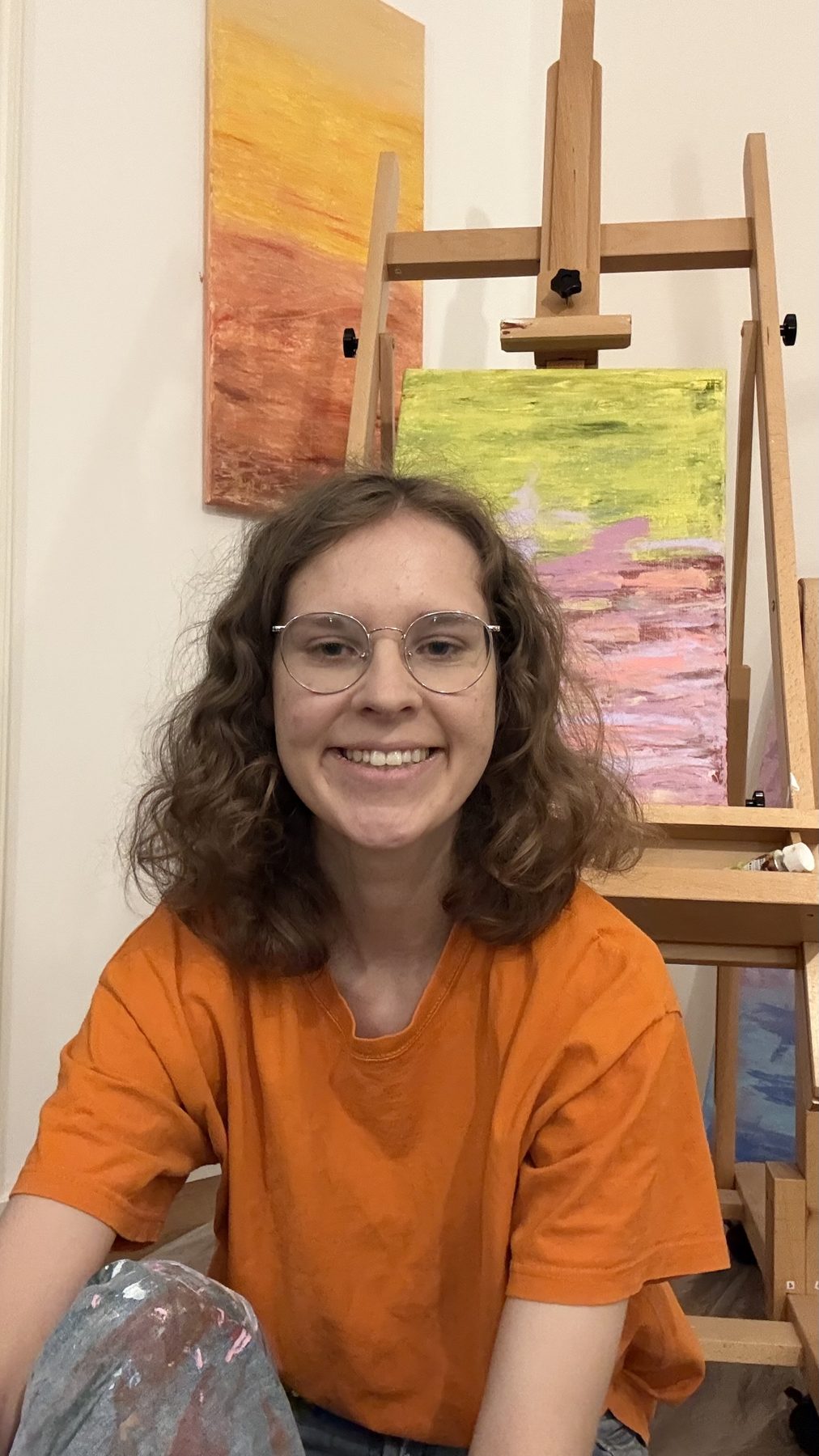 Lina in ihrem Atelier vor Staffelei und Acrylbildern